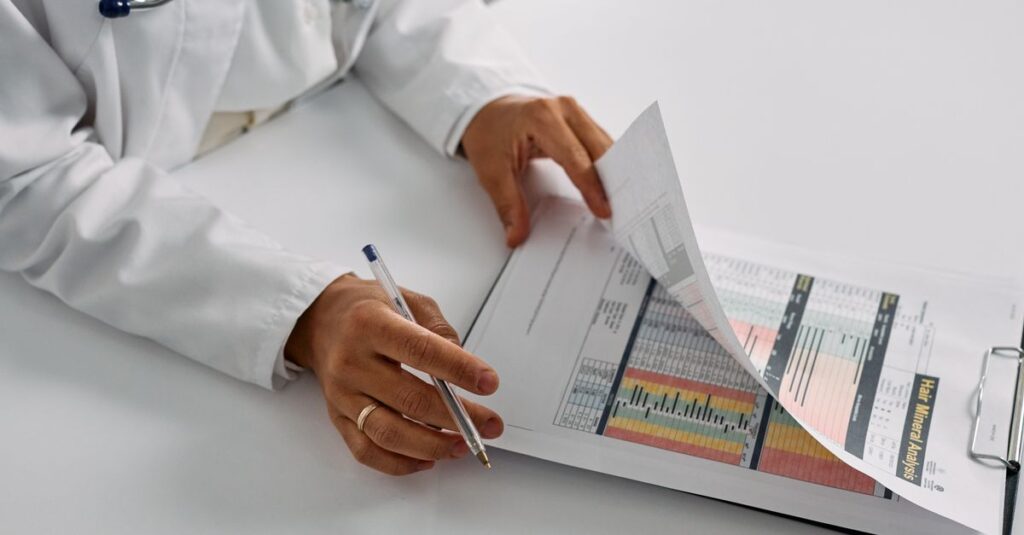 Médico revisando documentos sobre a mesa, ilustrando resposta a denúncia no Conselho de Medicina