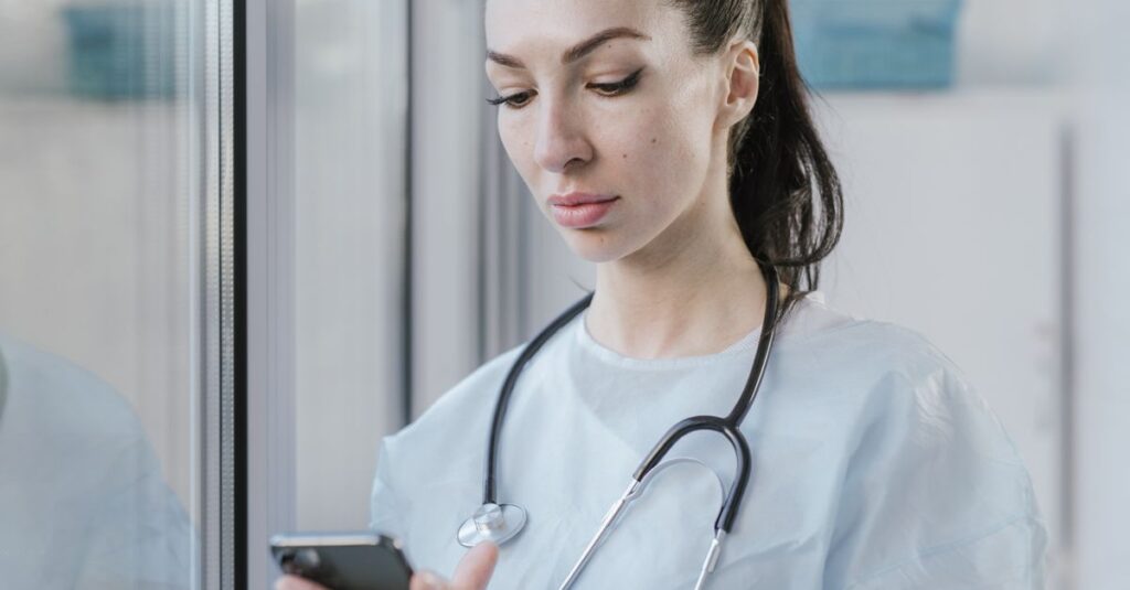 Médica de jaleco consultando o celular: fiscalização do CFM com inteligência artificial alcança as redes sociais