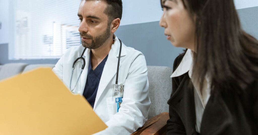 Médico analisando registros clínicos com o paciente em consultório, representando a conduta do médico assistente.