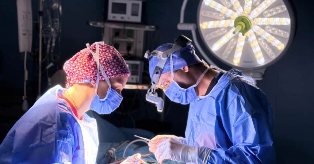 Equipe médica em centro cirúrgico durante procedimento, ilustrando defesa do médico em processo por erro