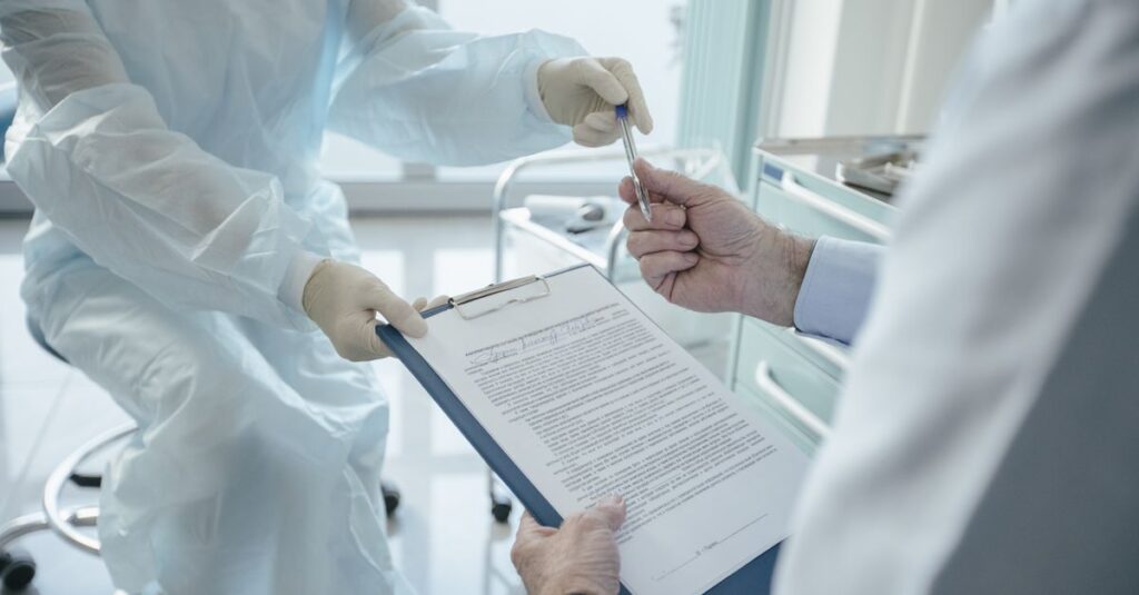 Médico assinando contrato de plantão sobre a mesa