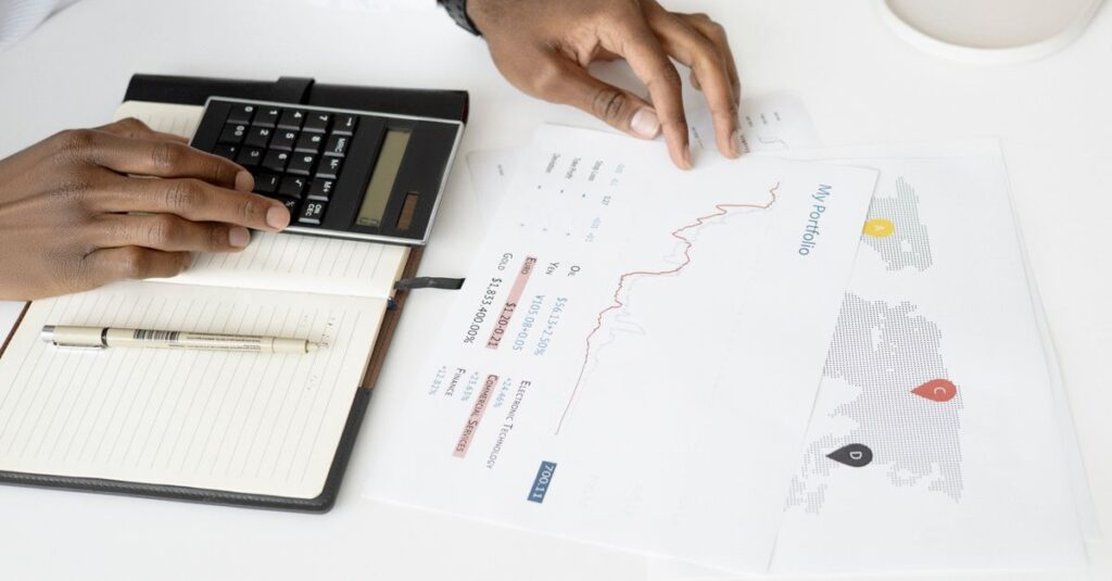 Calculadora e documentos financeiros sobre a mesa, ilustrando o Fator R do médico no Simples Nacional