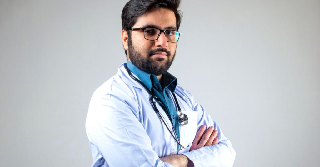 Médico com jaleco branco em consultório, representando o registro do título de especialista