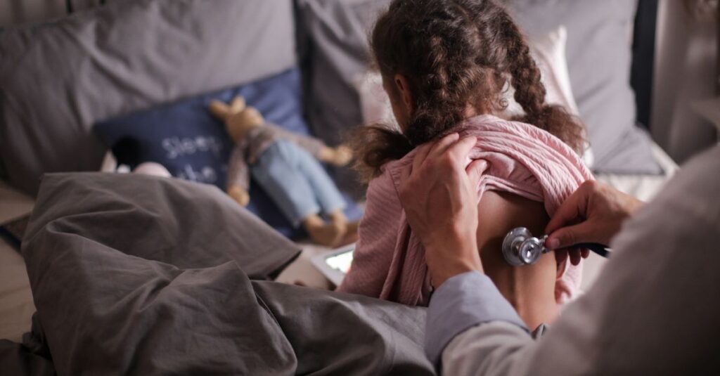 Médico em consulta com criança durante avaliação clínica do autismo TEA