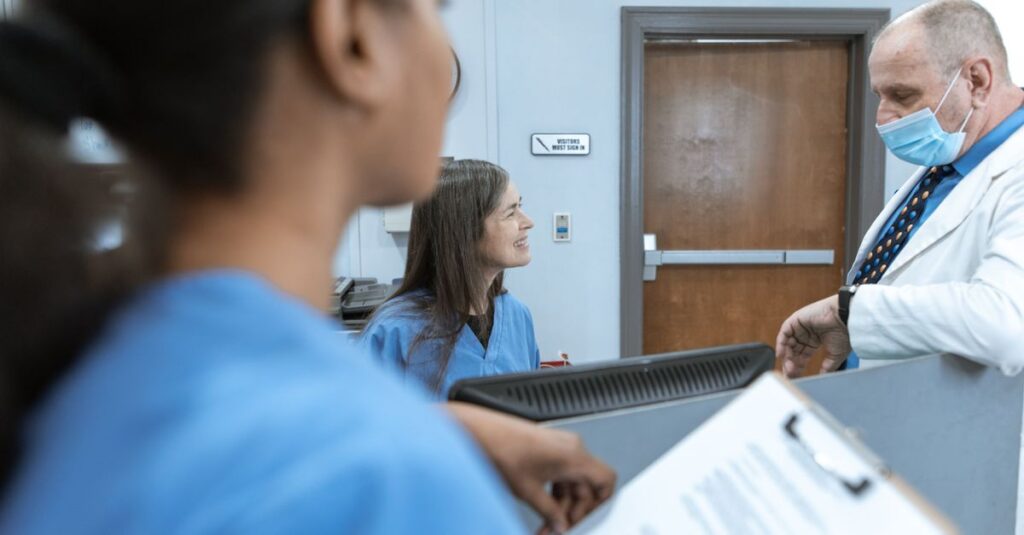 Equipe médica reunida em hospital analisando prontuários, imagem que ilustra a Comissão de Revisão de Óbito