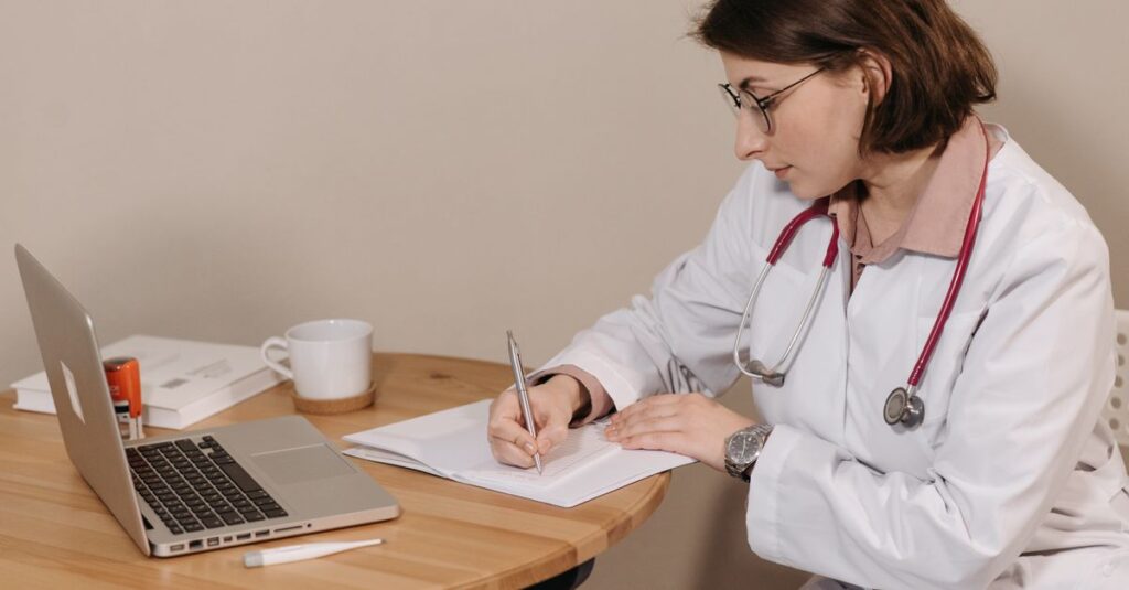 Médico sentado à mesa revisando documentos com expressão concentrada
