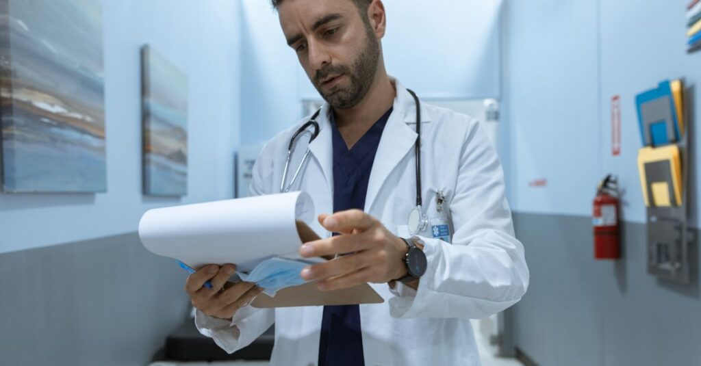 Médico analisando documentos de uma sindicância do CRM sobre a mesa