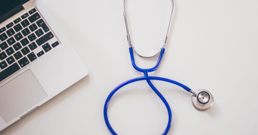 Estetoscópio sobre a mesa de um médico, ao lado de documentos de defesa do médico