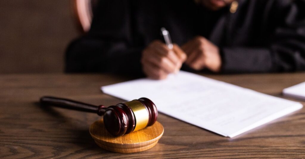 Mesa com balança da justiça, tema da defesa do médico em processo por erro médico