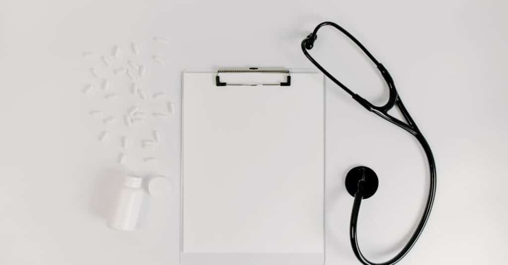 Prontuário e estetoscópio sobre a mesa durante análise de perícia médica