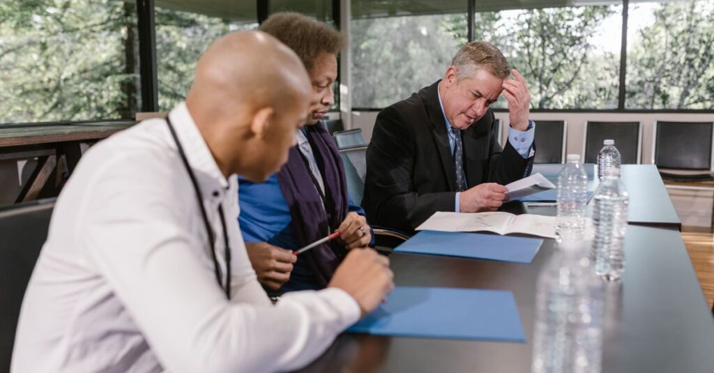 Médico em reunião formal analisando documentos antes da sessão de julgamento no CRM