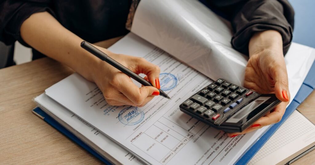 Mesa com calculadora e documentos de impostos para análise tributária de clínica médica