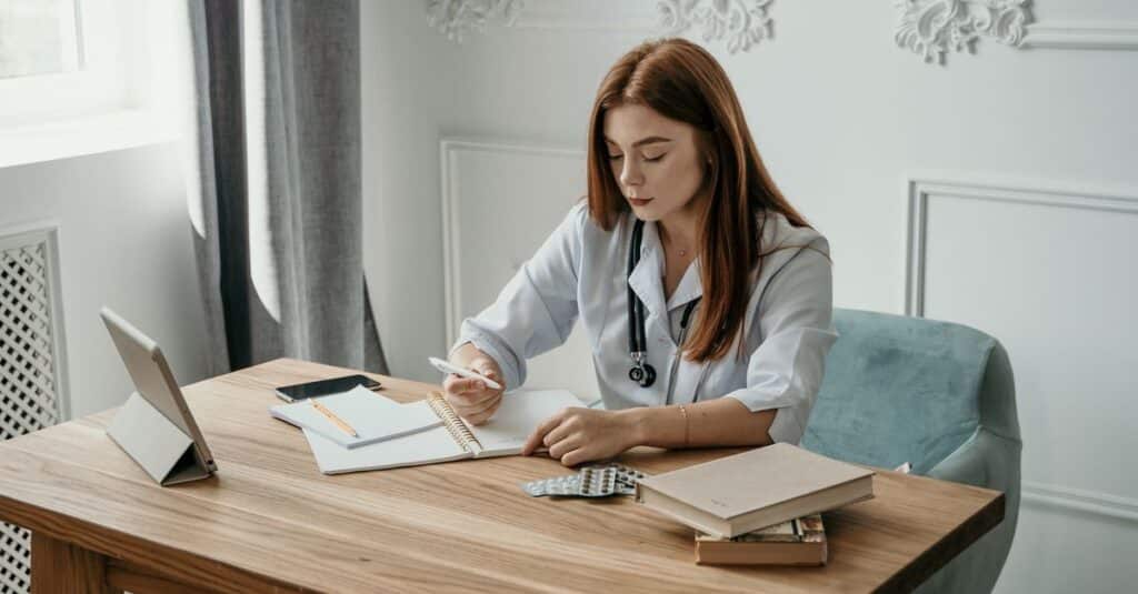 Médico preenchendo documentos para responder a uma sindicância no Conselho Regional de Medicina